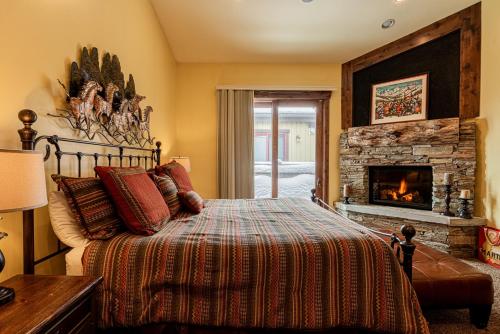 um quarto com uma cama e uma lareira em Badgerland Park City - Summer Escape with Year-Round Recreation, Mountain Trail and Private Hot Tub! em Park City