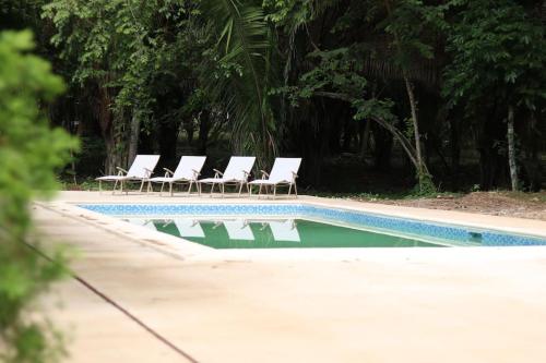 a group of chairs sitting next to a swimming pool at Central Oasis Private Pool BBQ in Belmopan