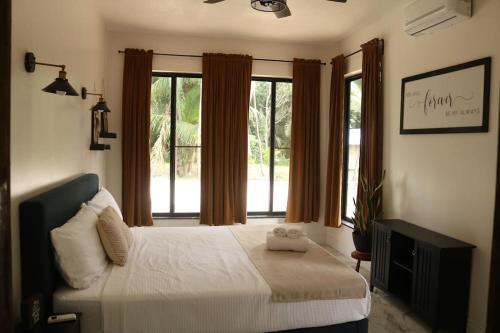 a bedroom with a bed and a large window at Central Oasis Private Pool BBQ in Belmopan