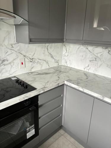 a kitchen with white marble counter tops and a stove at Centre reache in Southend-on-Sea