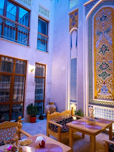 une chambre avec une table et des chaises et un bâtiment dans l'établissement Meros Hotel, à Boukhara