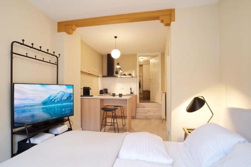 1 Schlafzimmer mit einem weißen Bett und einer Küche in der Unterkunft Schöne Fewo im Winzerdorf - Sauna - Sonnenterrasse in Ürzig