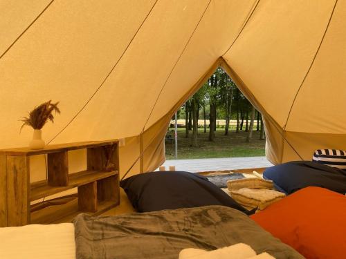 uma tenda com duas camas e uma janela em The Elm: Luxury Bell Tent with private bathroom em Toppesfield
