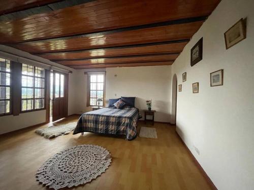 ein Schlafzimmer mit einem Bett und einer Holzdecke in der Unterkunft Caricari Casa Campestre Sogamoso in Sogamoso