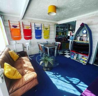 a living room with a couch and a table at The Beach Hut in Scratby