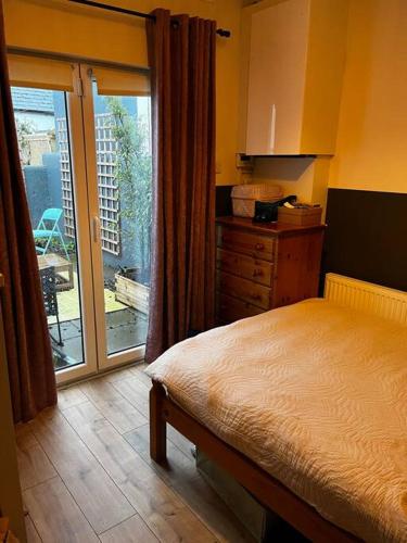 a bedroom with a bed and a sliding glass door at Trendy artisan cottage in Stoneybatter near Dublin City centre in Dublin