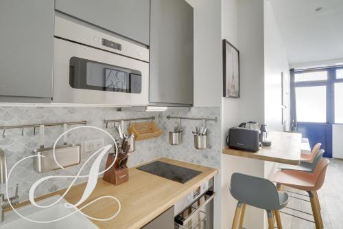 une cuisine avec un évier et un plan de travail dans l'établissement Cyrano, Appartement moderne 2 chambres Paris 14eme, à Paris