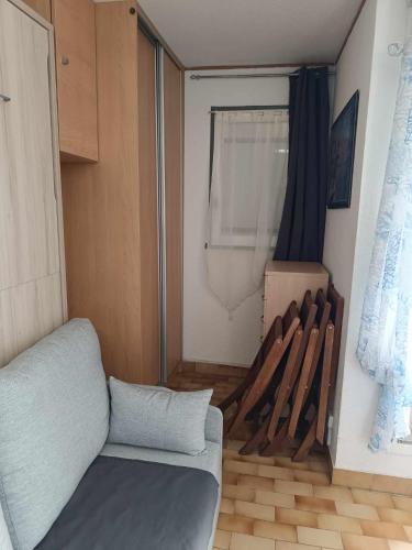 un salon avec un canapé et un tas de chauves-souris dans l'établissement appartement avec terrasse, au Cap d'Agde