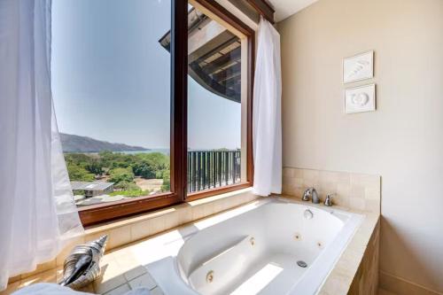 un bagno con ampia vasca e finestra di Hermosa Vida a Playa Hermosa