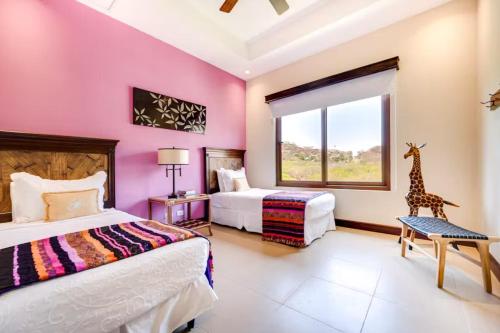 um quarto com duas camas e uma girafa na janela em Hermosa Vida em Playa Hermosa