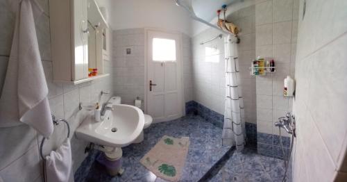 a white bathroom with a sink and a shower at Agape’s apartment in Anaxos