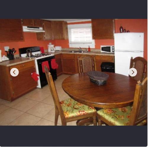 a kitchen with a wooden table and a table and chairs at India House Hostel in New Orleans