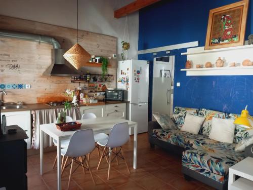 Casita Mona y Acogedora في ألكواس: مطبخ وغرفة معيشة مع طاولة وأريكة