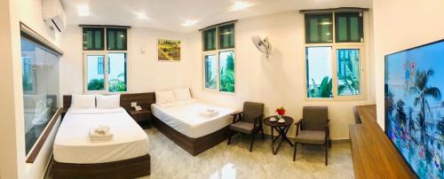 a hotel room with two beds and a tv at Kalia Hotel in Phu Quoc