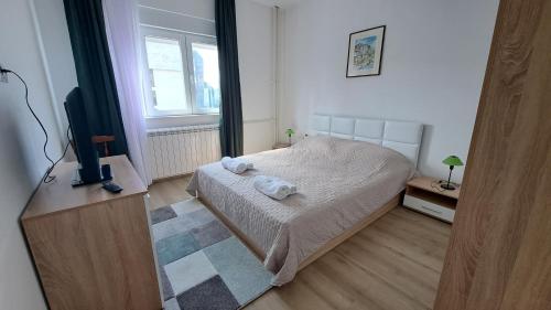 a bedroom with a bed and a flat screen tv at Vera City Square Apartment in Skopje