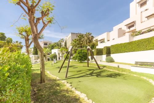 einen Park mit einer Schaukel im Gras in der Unterkunft Full apartment with private pool in Estepona