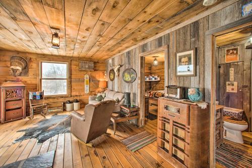 a living room with wooden walls and a wooden ceiling at Secluded Powersville Cabin 25 Mi to Lake Paho! 