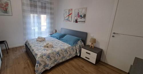 una camera da letto con letto con lenzuola blu e comodino di Appartamento Albachiara a La Spezia