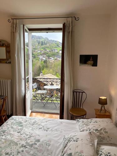 een slaapkamer met een bed en uitzicht op een balkon bij Chambre centre Saint-Gervais Mont-Blanc in Saint-Gervais-les-Bains