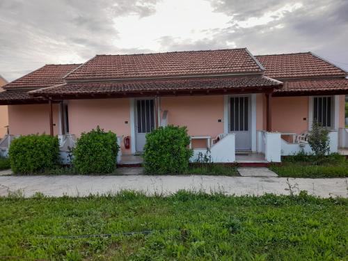 a pink house with a tile roof at Sidari Studios in Sidari