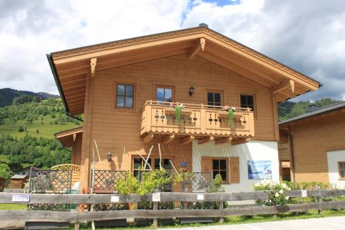a wooden house with a balcony on top at Alpen Chalets Zell am See in Niedernsill