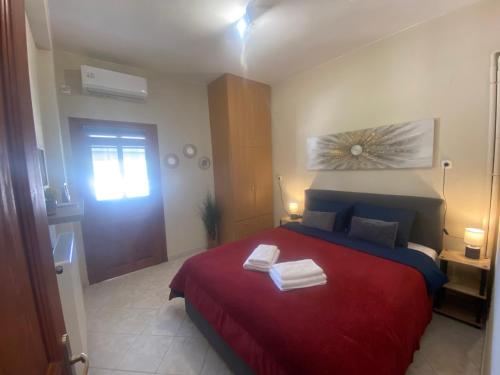 a bedroom with a red bed with two towels on it at ZoYa ‘s Apartments in Agria