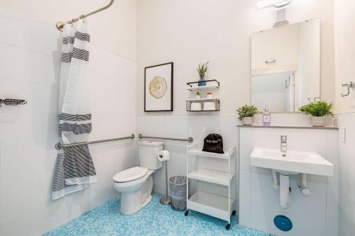 a white bathroom with a toilet and a sink at Fremont Urban Studio in Seattle