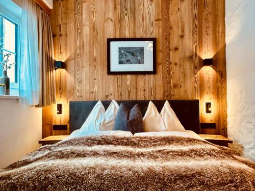 ビヒルバッハにあるSonn-Alm Chalet-Apartmentsの木製の壁のベッドルーム1室(ベッド1台付)