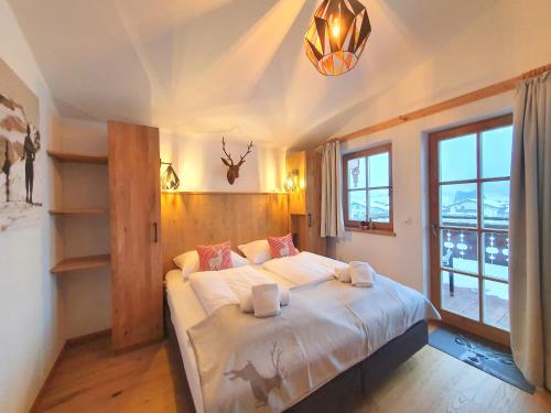 Alpen Chalets Zell am See في نيدرمسيل: غرفة نوم بسرير ونافذة كبيرة