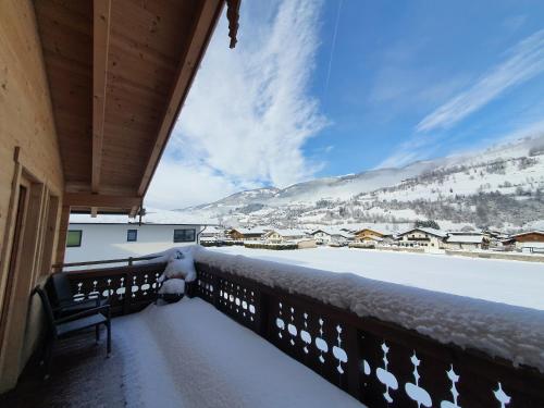 a balcony covered in snow with a view of the mountains at Alpen Chalets Zell am See in Niedernsill
