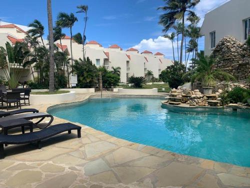 uma piscina num resort com palmeiras em Cabarete Beachfront Condos Nanny Estate A3 em Cabarete