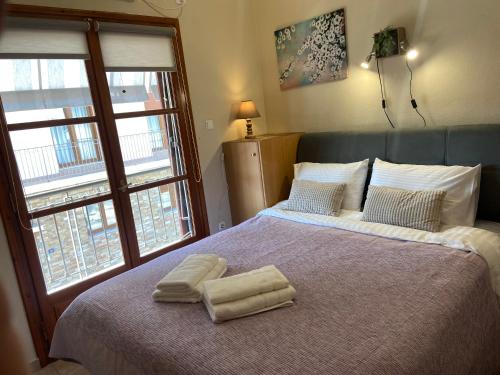 a bedroom with a bed with two towels on it at ZoYa ‘s Apartments in Agria