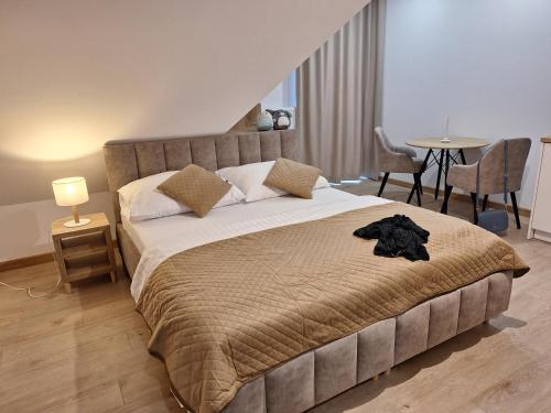 a bedroom with a large bed and a table with chairs at APP Biały Dunajec in Biały Dunajec