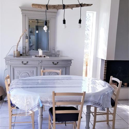 une salle à manger avec une table et des chaises blanches dans l'établissement Villa Le P'tit Bassin à Arès, sur le Bassin d'Arcachon côté Cap-Ferret, à Arès