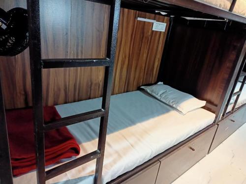 a bunk bed on a ladder in a room at Golden View Dormitory in Mumbai
