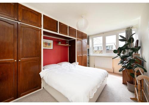 a bedroom with a white bed and a red wall at chic 3-BR home welll located in Islington in London