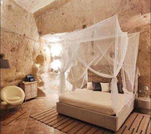 a bedroom with a bed with a mosquito net at Stone House in Matera