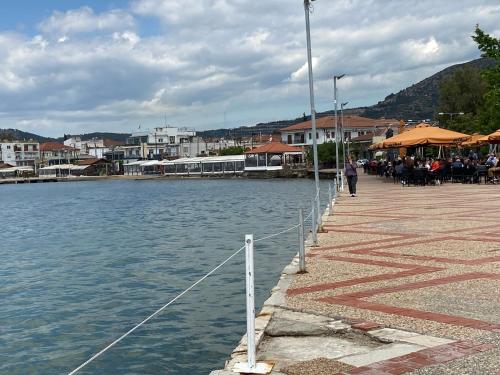 a group of people sitting at a pier next to the water at ZoYa ‘s Apartments in Agria