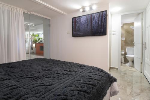 a bedroom with a black bed and a bathroom at Real Superbike at your home - Bahai Gardens center in Haifa