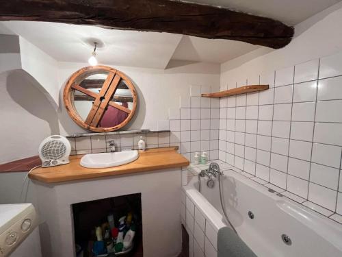 La salle de bains est pourvue d'une cheminée, d'un lavabo et d'une baignoire. dans l'établissement Charmante maison à Fillols, à Fillols