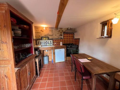 - une cuisine avec une table en bois et une table sidx sidx sidx dans l'établissement Charmante maison à Fillols, à Fillols