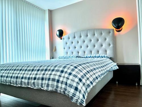 ein Schlafzimmer mit einem Bett mit einer karierten Decke in der Unterkunft Aquarius at St. George Wharf in London