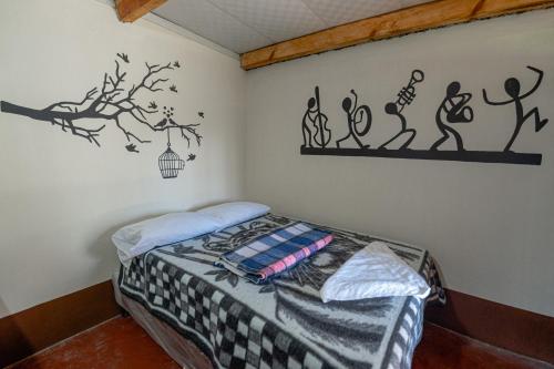 ein Schlafzimmer mit einem Bett in einem Zimmer mit einer Wand in der Unterkunft Salvaxia in Chichicastenango
