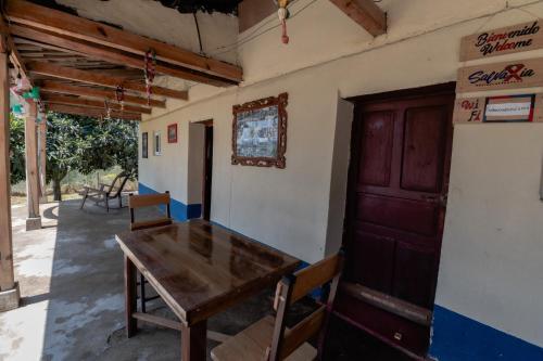 Habitación con mesa de madera y puerta en Salvaxia en Chichicastenango