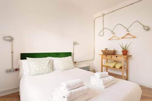 een slaapkamer met een wit bed met handdoeken erop bij Eulalias Lodges Barcelona in Barcelona