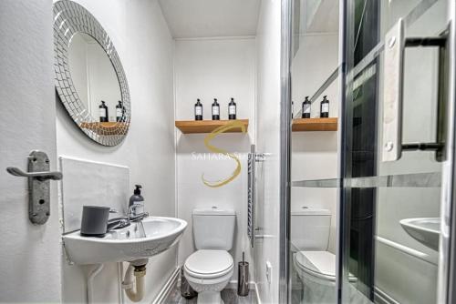 W łazience znajduje się umywalka, toaleta i lustro. w obiekcie Luxe 3 Bed Central Nottingham w Nottingham