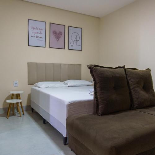 um quarto com uma cama e um sofá em De Paula Apart Hotel em Espigão dʼOeste