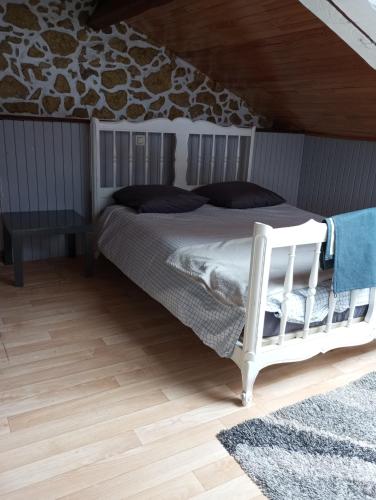 une chambre avec un lit blanc et un parquet dans l'établissement Appartement, à Saint-Pandelon