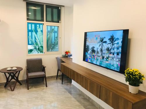 una sala d'attesa con una grande TV a schermo piatto a parete di Kalia Hotel a Phu Quoc