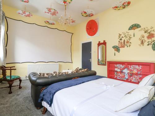 a bedroom with a large bed with a red headboard at The Funky Flat in Holywell